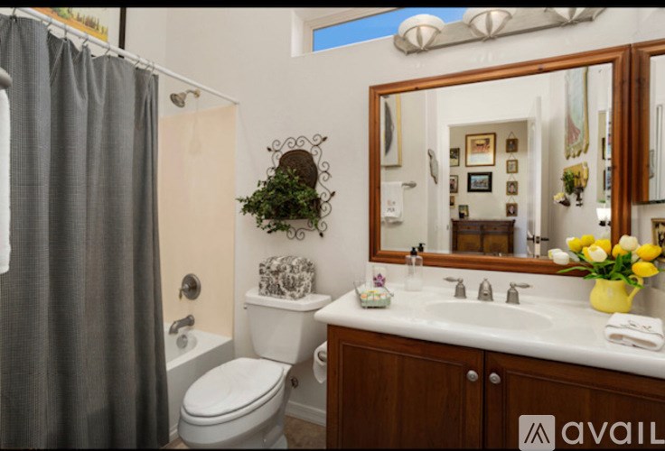 A bathroom with a toilet, sink, and mirror.