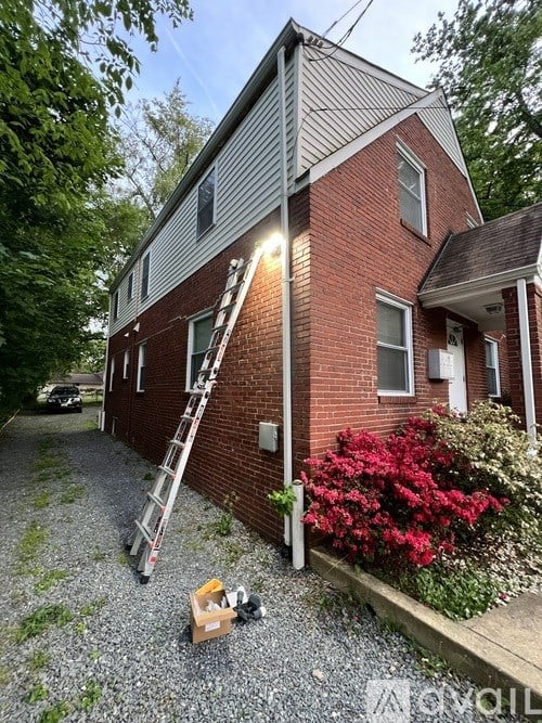 A red brick house with a ladder leaning against it.