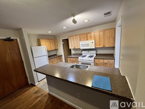 A kitchen with wooden cabinets and a granite countertop.