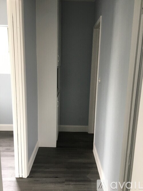 A room with a white door and grey walls.
