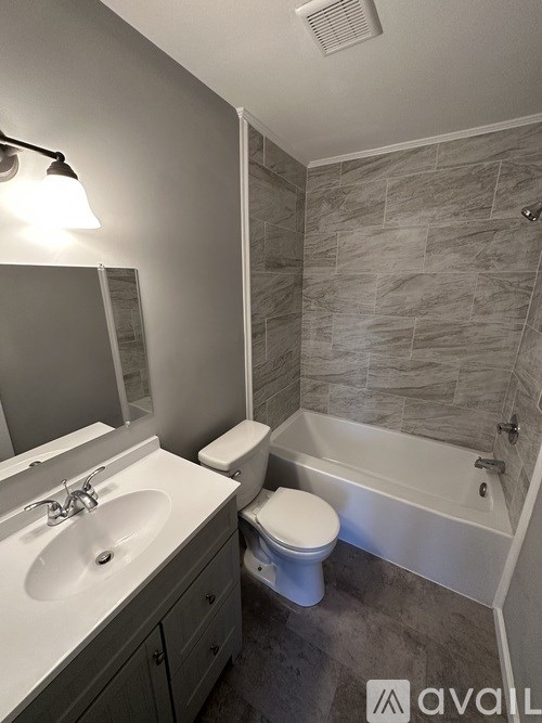 A bathroom with a sink, toilet, and bathtub.