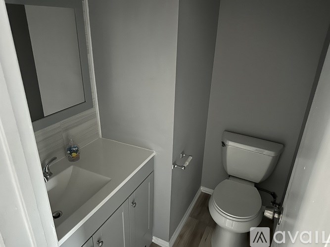 A bathroom with a toilet, sink, and medicine cabinet.
