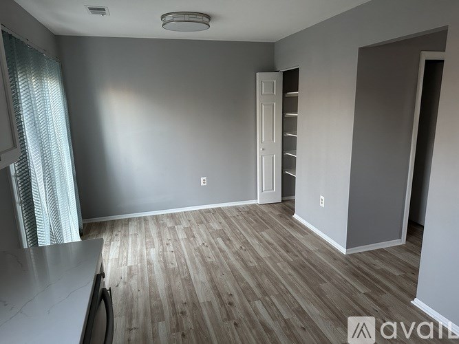 A room with wooden flooring and a white door.