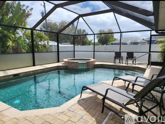 A pool with a glass enclosure and a hot tub.