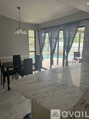 A dining area with a marble table and chairs.
