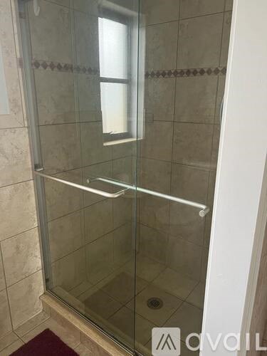 A glass shower door in a bathroom.