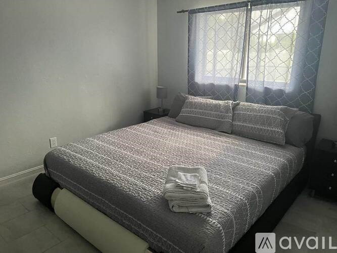 A bed with a grey blanket and two pillows is in the image.