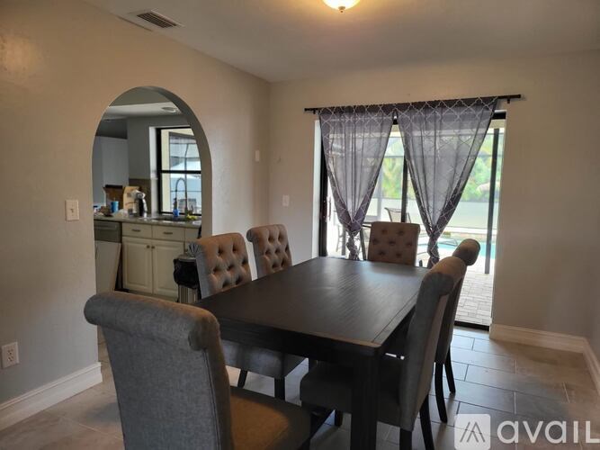 A dining room with a table and chairs.