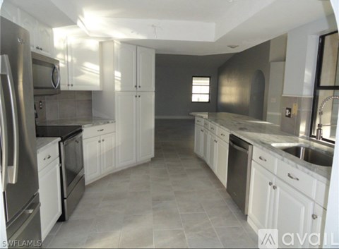 A kitchen with white cabinets and stainless steel appliances.
