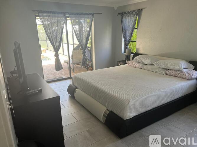 A bedroom with a large bed and a television.