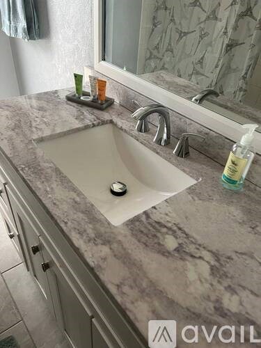 A bathroom sink with a marble countertop and a silver faucet.