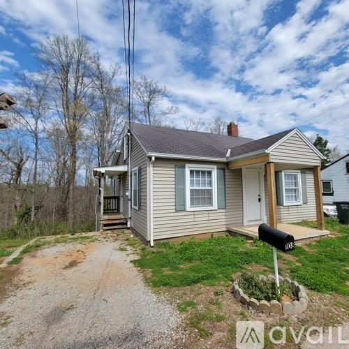 A house with a grey roof and a mailbox in front of it.
