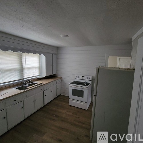 A kitchen with white cabinets and a stove top oven.