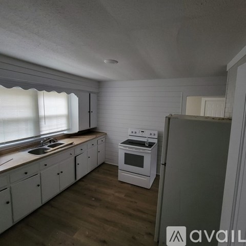 A kitchen with white cabinets and a stove top oven.