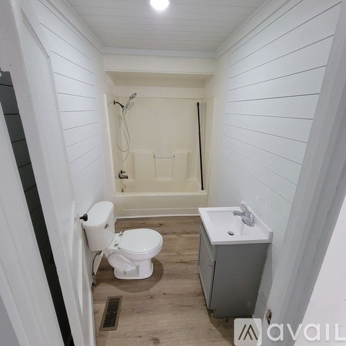 A white toilet sits next to a sink in a small bathroom.