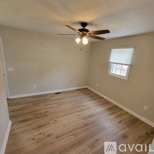 A room with wooden flooring and a ceiling fan.