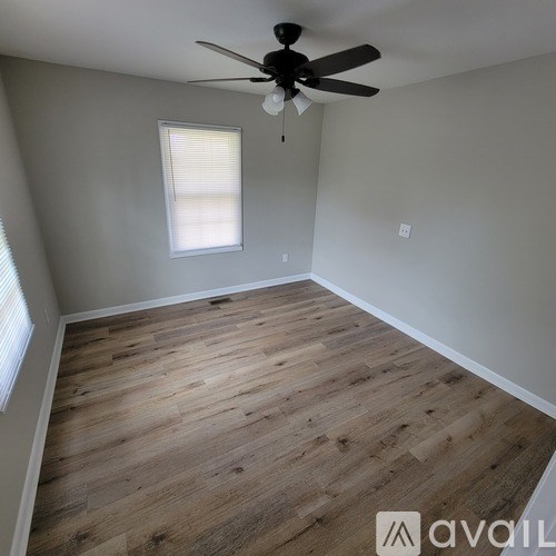 A room with wooden flooring and a ceiling fan.