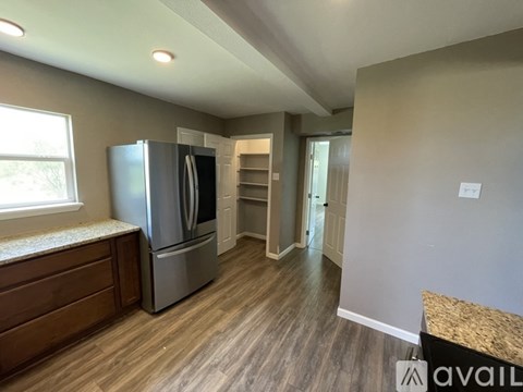 A kitchen with a refrigerator and a window.