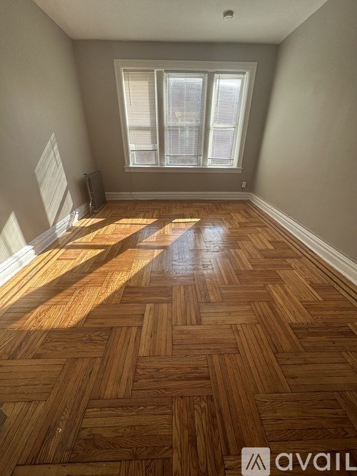 A room with wooden flooring and a window.