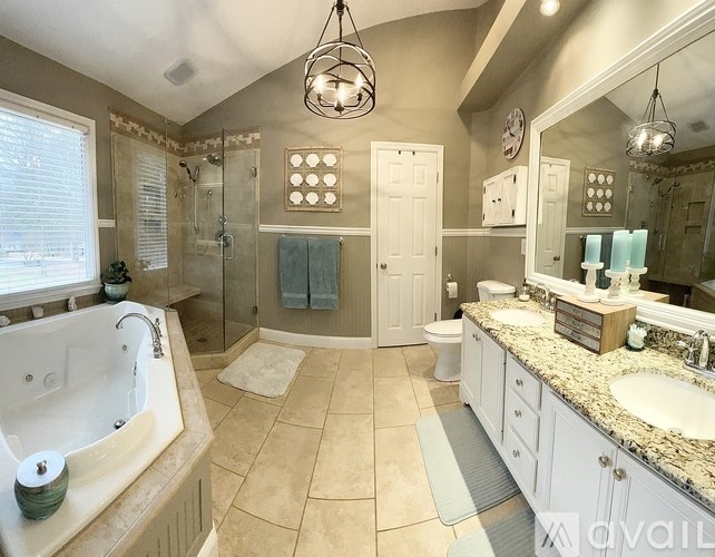 A bathroom with a large tub and double sinks.