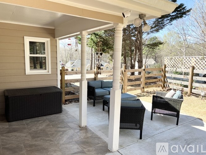 A patio with a table and chairs under a white pergola.