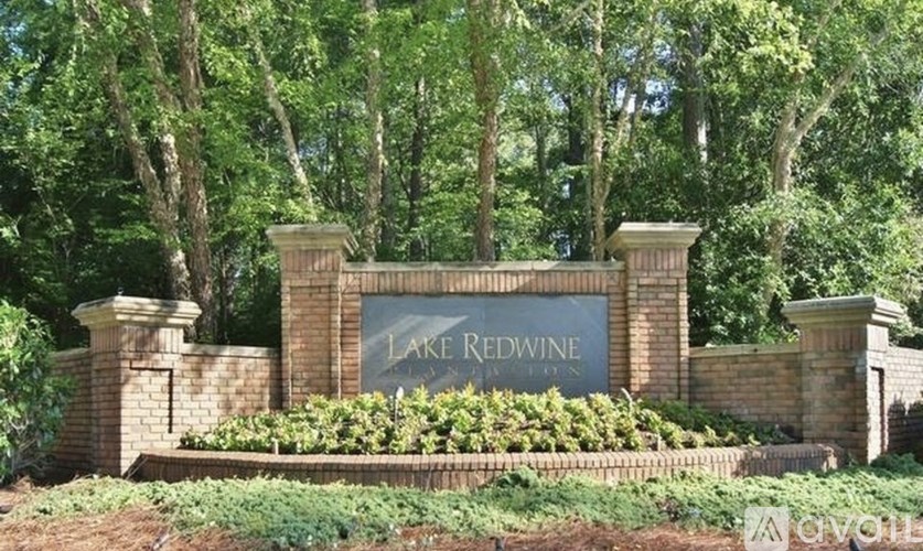 A sign that says Lake Redwine is in front of some trees.