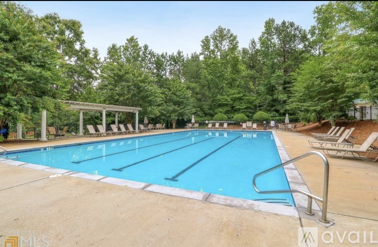 A large outdoor swimming pool surrounded by trees.