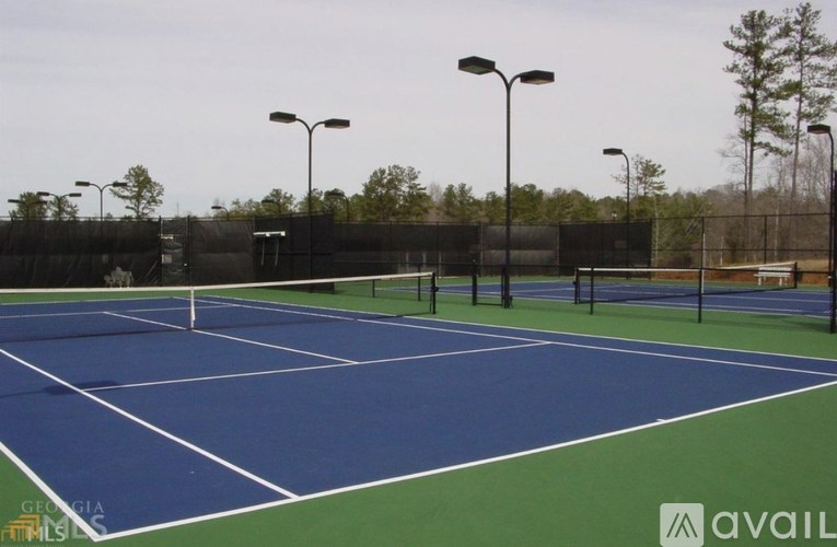 A tennis court with a blue surface and white lines.