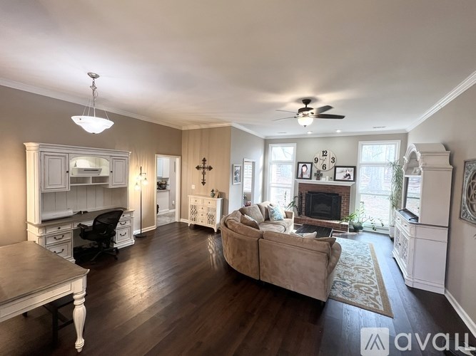 A living room with a couch, a table, and a fireplace.