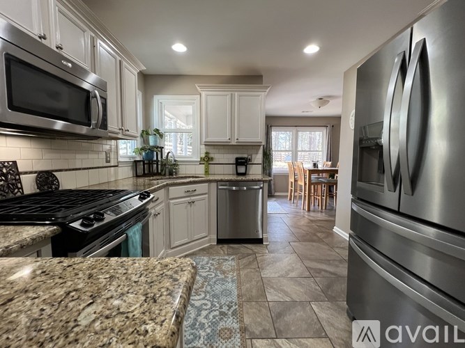 A modern kitchen with granite countertops and stainless steel appliances.