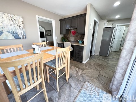 A kitchen with a table and chairs in front of it.
