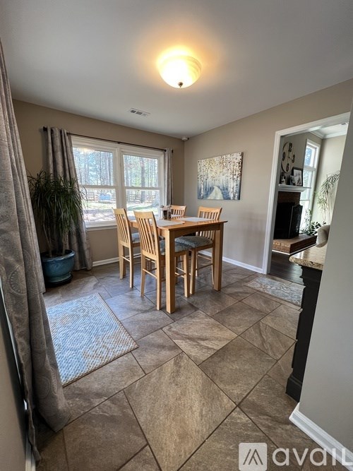 A dining room with a table and chairs.
