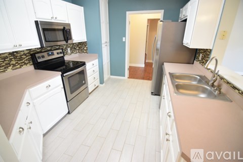 A kitchen with white cabinets and a black stove top oven.