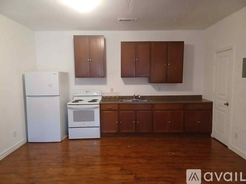 A kitchen with wooden cabinets and a white fridge.
