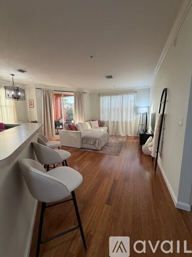 A living room with a white couch and a wooden floor.