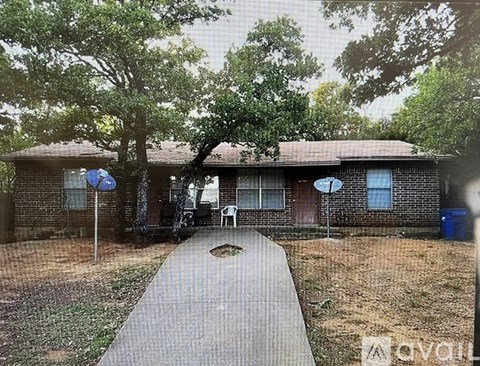 A house with a driveway and trees in front.
