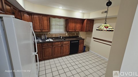 A kitchen with brown cabinets and a white refrigerator.