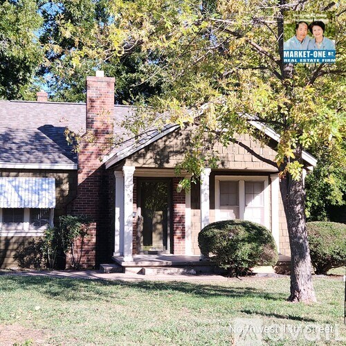 A house with a sign that says Market One Real Estate.
