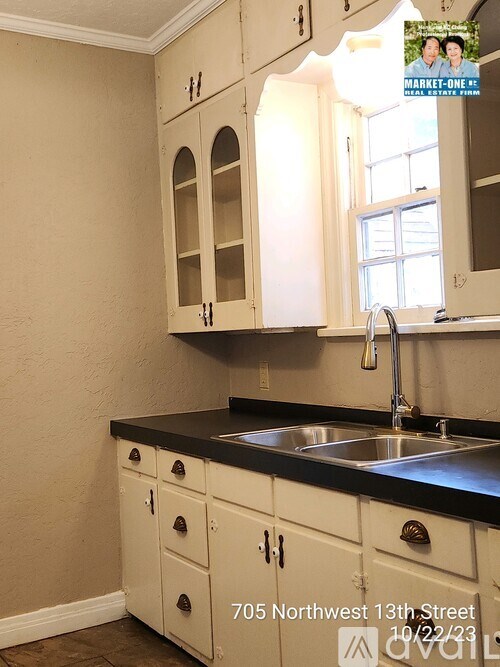 A kitchen with white cabinets and a black countertop.