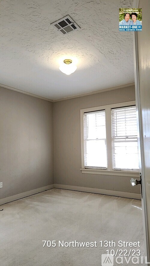 A room with a window and a light on the ceiling.