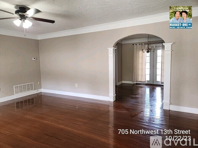 A room with a ceiling fan and a window with curtains.