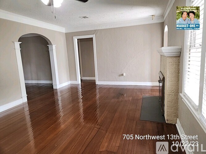 A room with wood flooring and a cat tree in the corner.