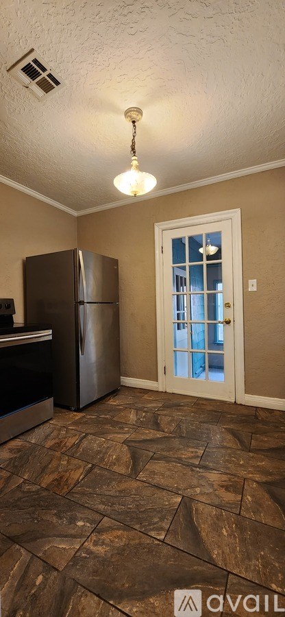 A kitchen with a refrigerator and a ceiling fan.