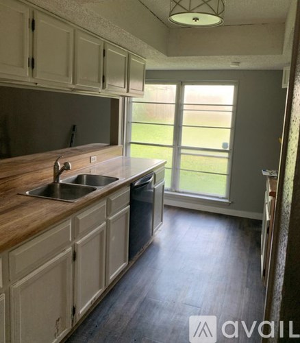 A kitchen with wooden countertops and white cabinets.
