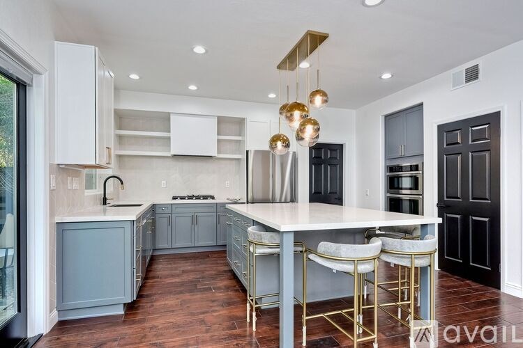 A modern kitchen with a large island and bar stools.