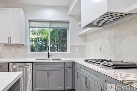 A kitchen with a stove top oven and a window.