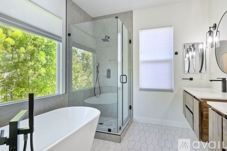 A modern bathroom with a large tub and a walk-in shower.
