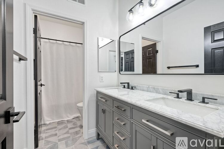 A bathroom with a sink, mirror, and shower.