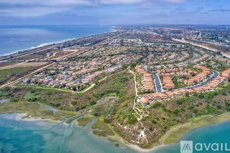 A bird's eye view of a coastal residential area with houses and roads.