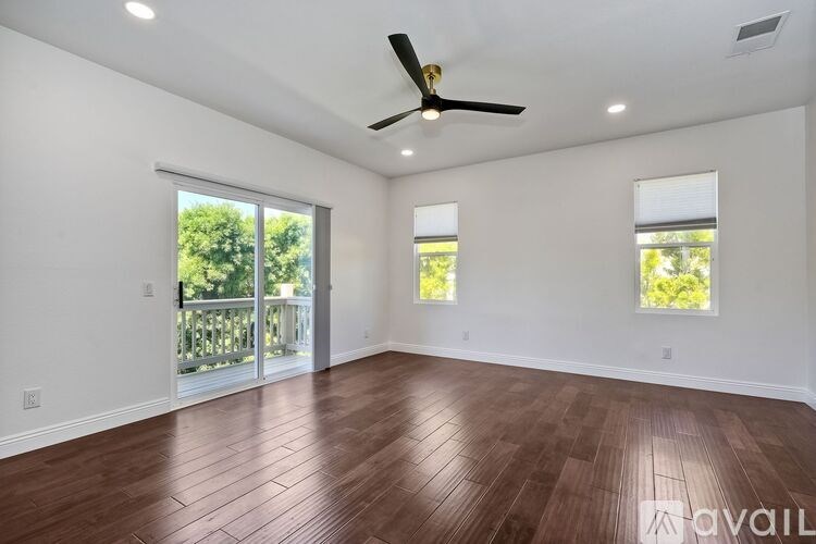 A room with wooden flooring and a ceiling fan.